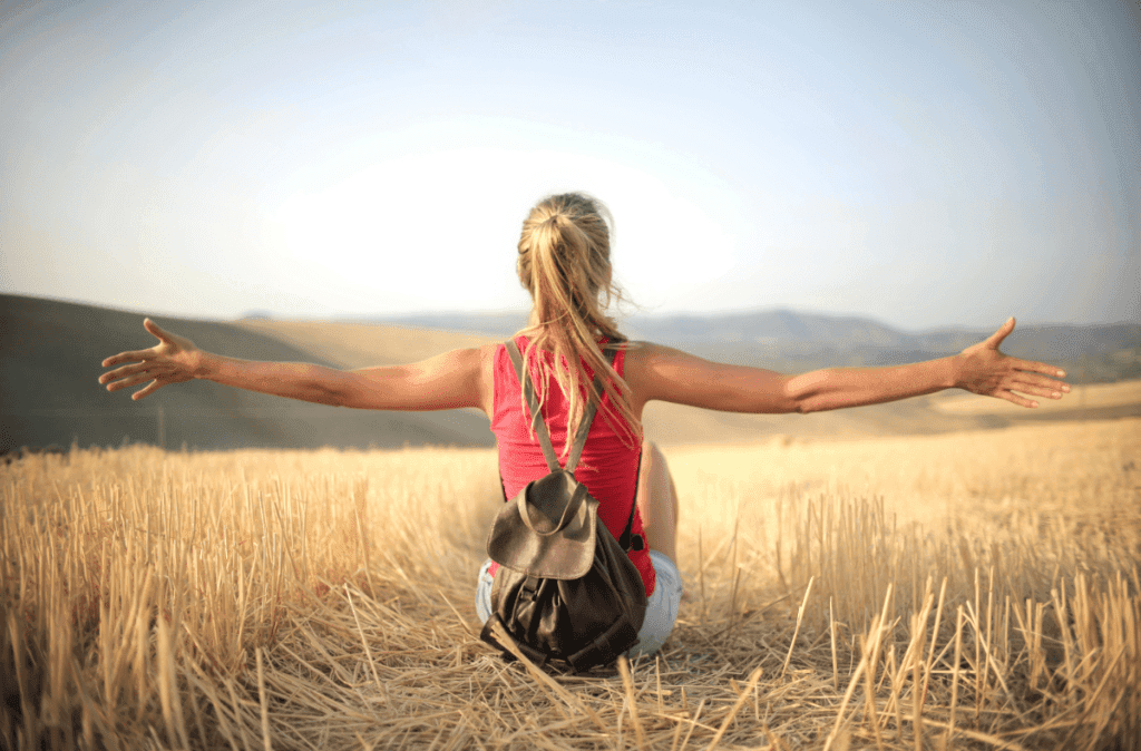 Woman sitting in field in the sunshine. 